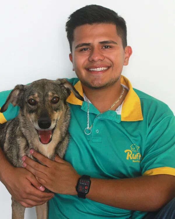 Samuel, pet sitter de Ruffinn Boutique Hotel, con un perro en brazos